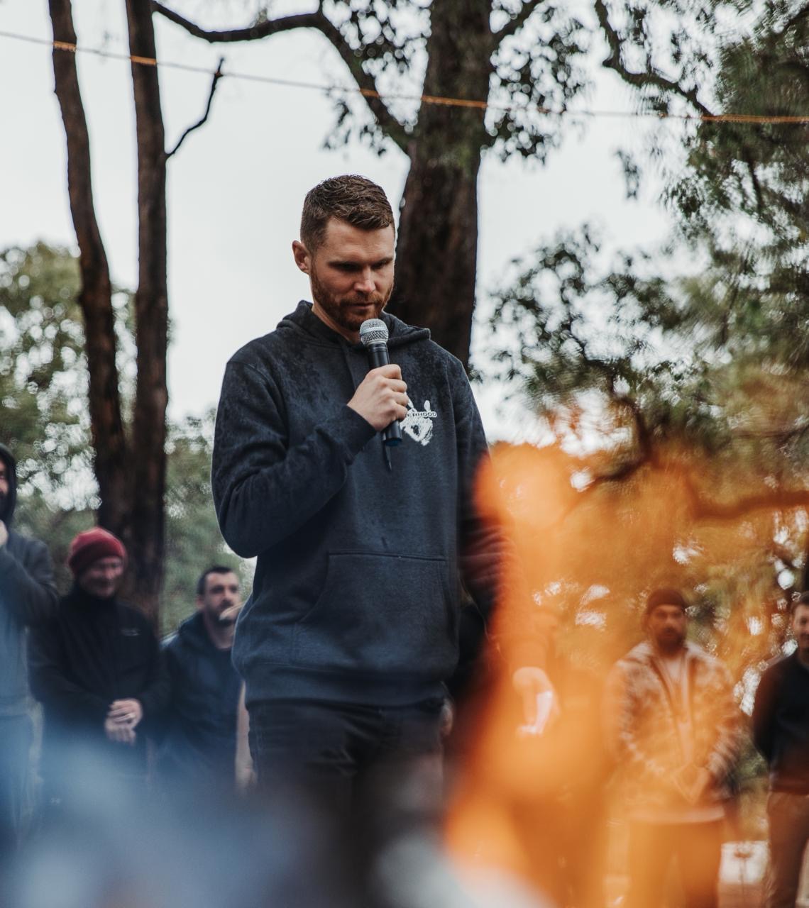 Man standing at a crossroads moment during initiation ceremony at The Disruption of Man retreat