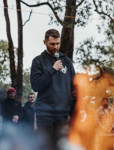 Man standing at a crossroads moment during initiation ceremony at The Disruption of Man retreat