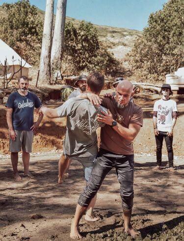 Man standing at a crossroads moment during initiation ceremony at The Disruption of Man retreat