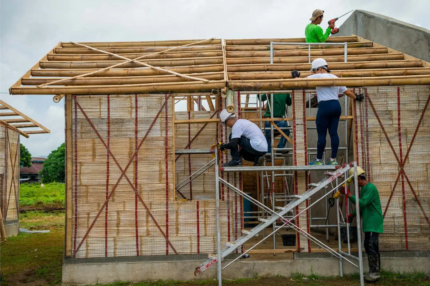 Students raising a bamboo structure on the Bamboo U campus