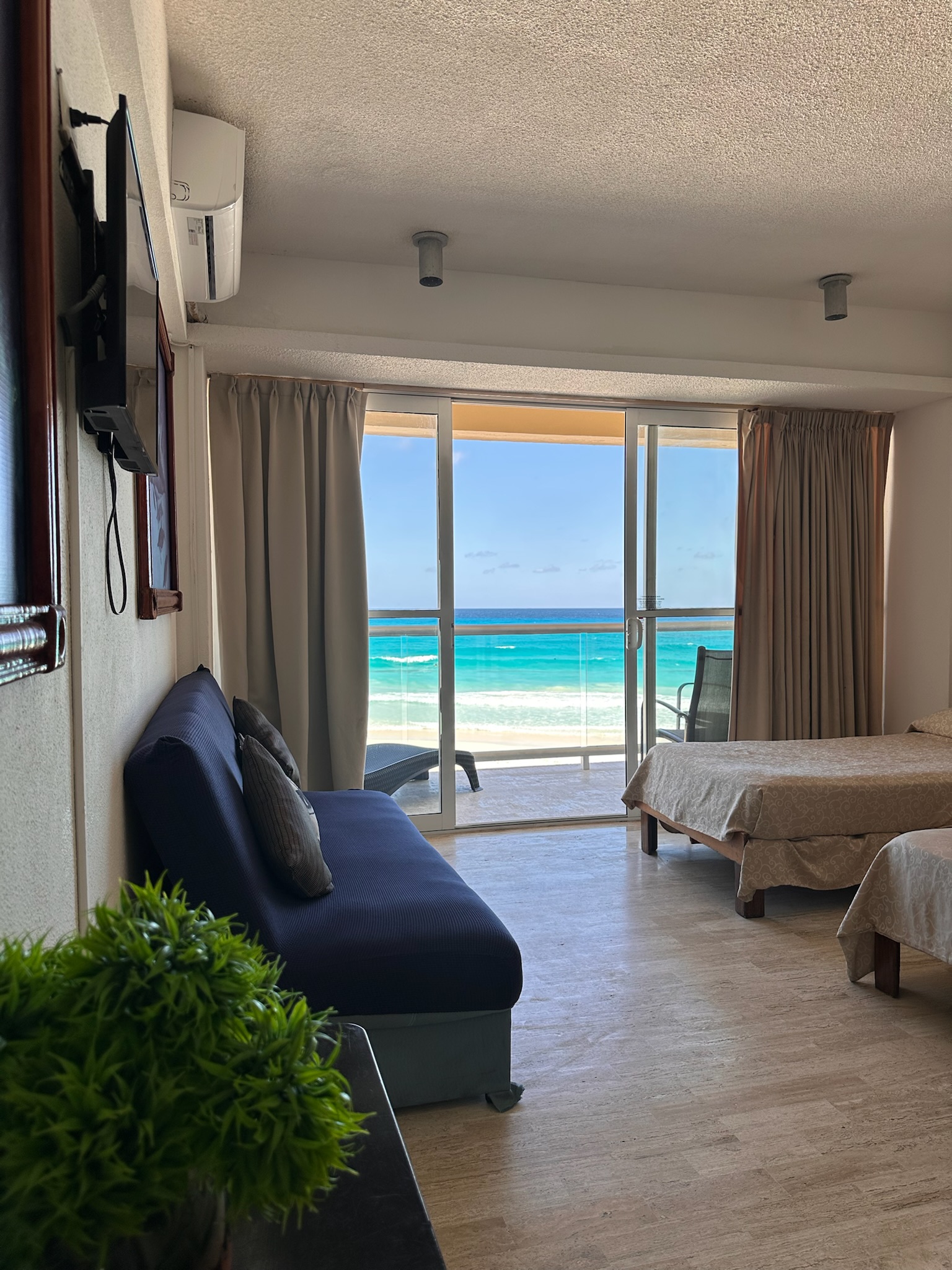 Habitación principal con camas preparadas, sábanas blancas y decoración moderna en el Departamento Salvia Cancún