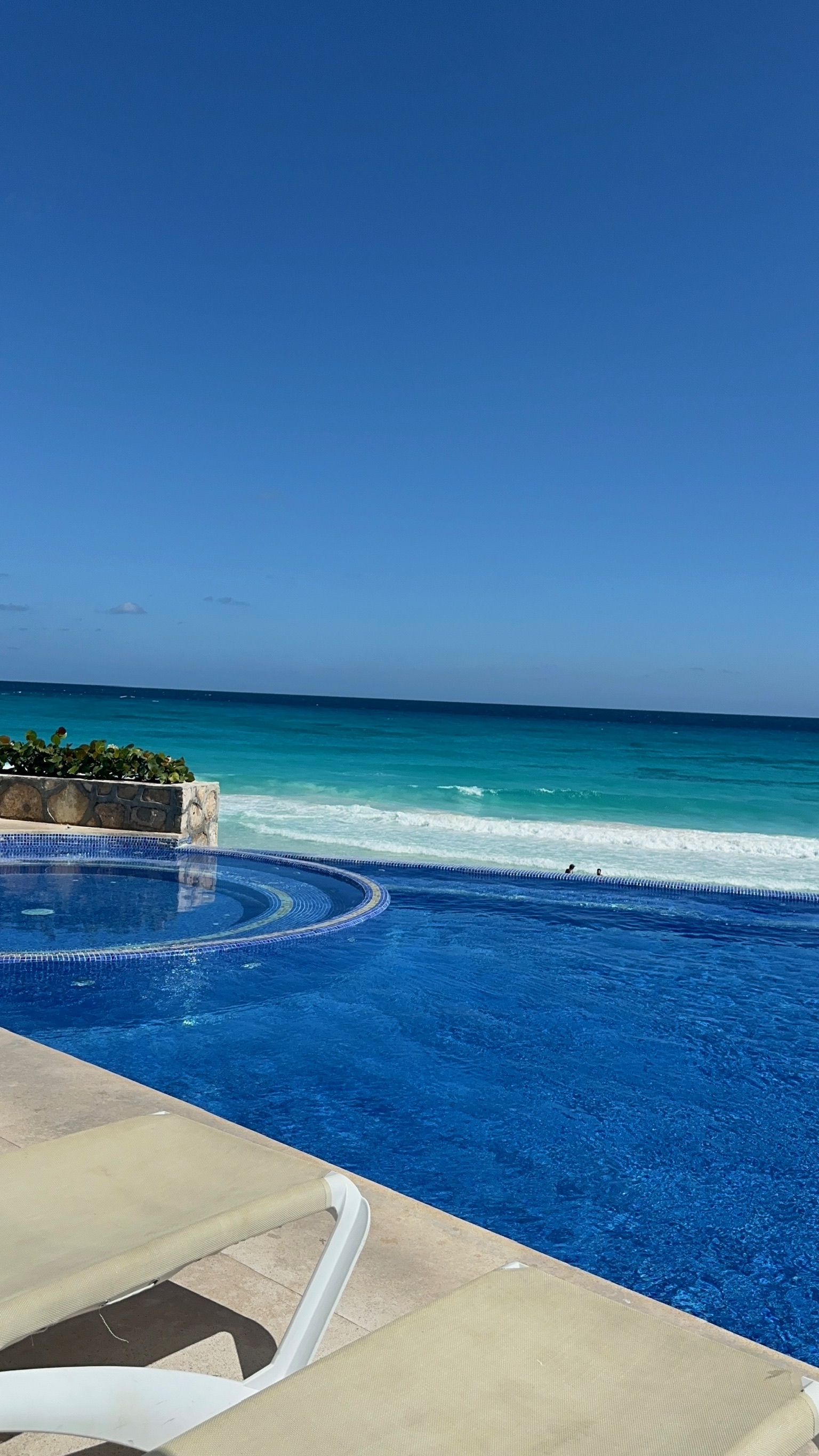 Albercas infinity al aire libre en el complejo Ocean Dreams Cancún con camastros, poolbar y espectaculares vistas frente al mar