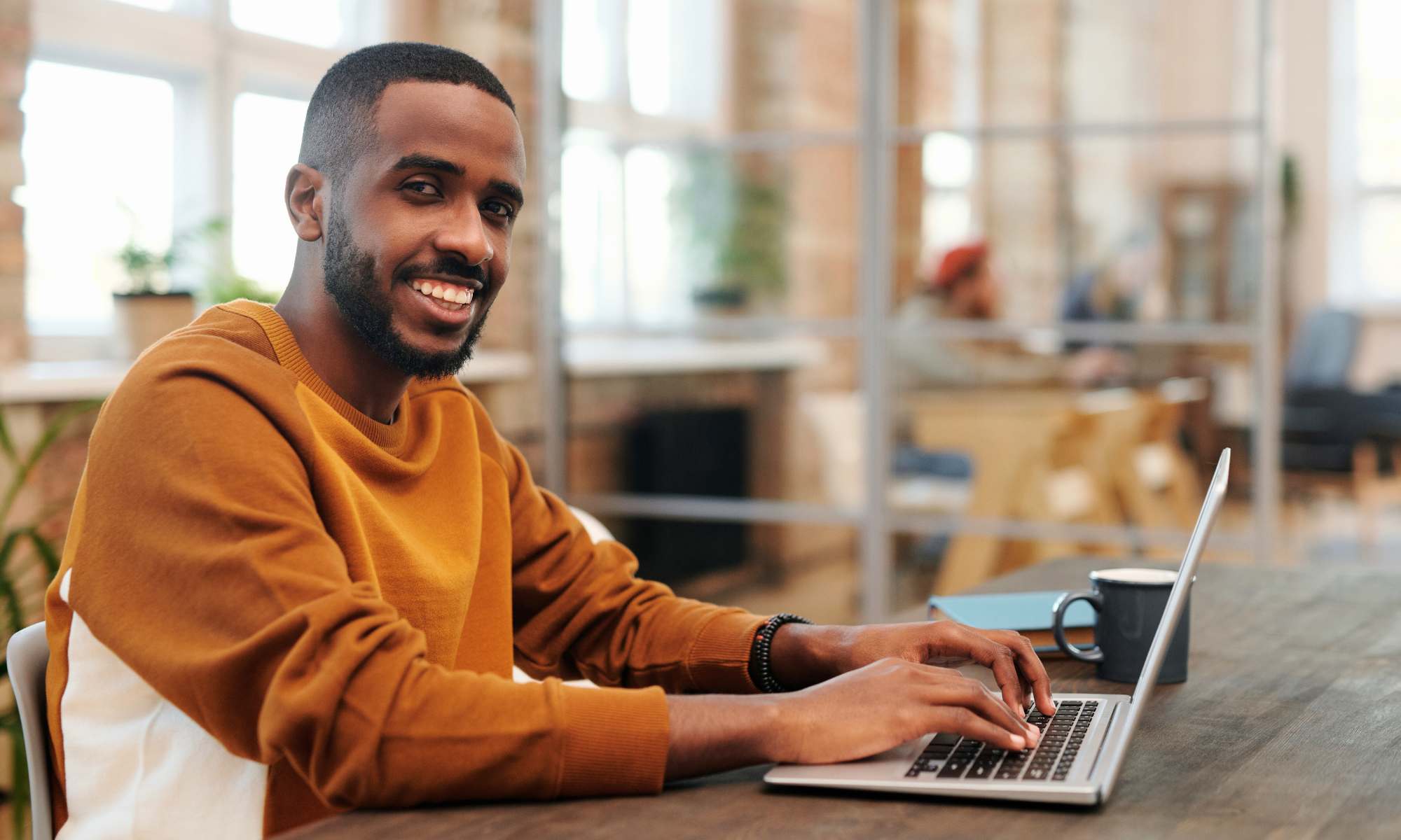 Man using computer for online Bible college at TBCS