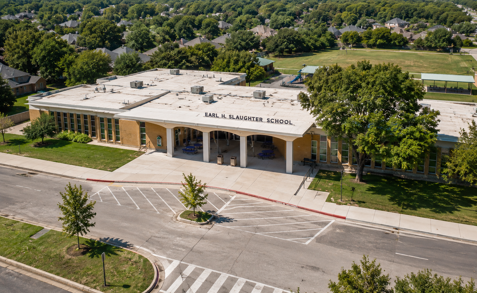 Aerial view of Earl H. Slaughter Elementary School in McKinney, Texas, showing the McKinney ISD school campus, main entrance, playground, green space, and surrounding residential neighborhoods.