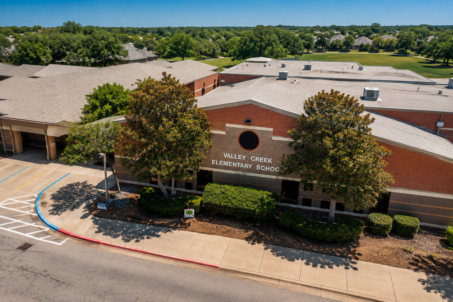 Aerial view of Valley Creek Elementary School in McKinney, Texas, showing the McKinney ISD school campus, main entrance, green space, and surrounding residential neighborhoods.