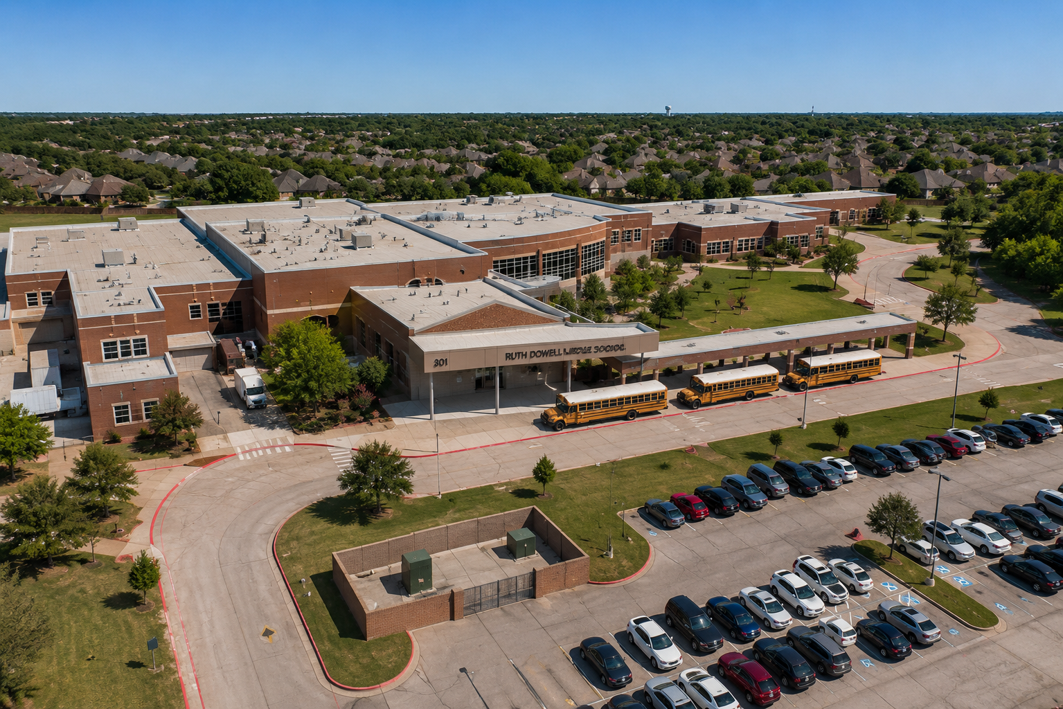 Aerial view of Ruth Dowell Middle School in McKinney, Texas, showing the McKinney ISD campus, main entrance, school buses, parking areas, and surrounding residential neighborhoods.