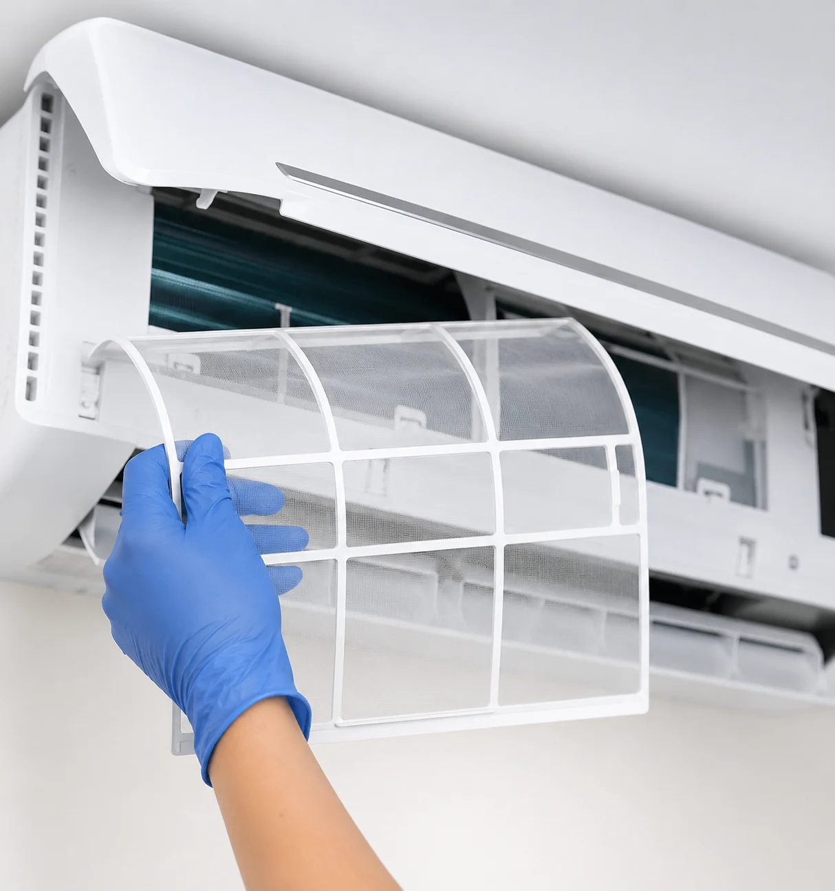 Air conditioning maintenance technician cleaning AC filter for improved system efficiency