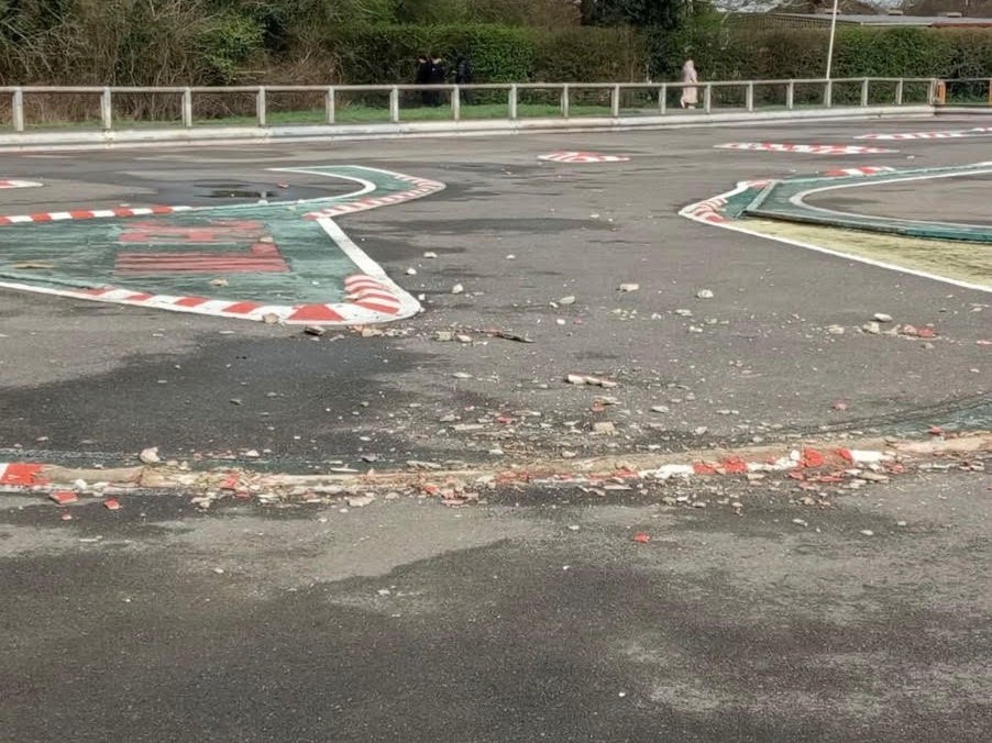 Smashed red-and-white kerbing and rubble across the Pole Hill track after vandalism in March 2026