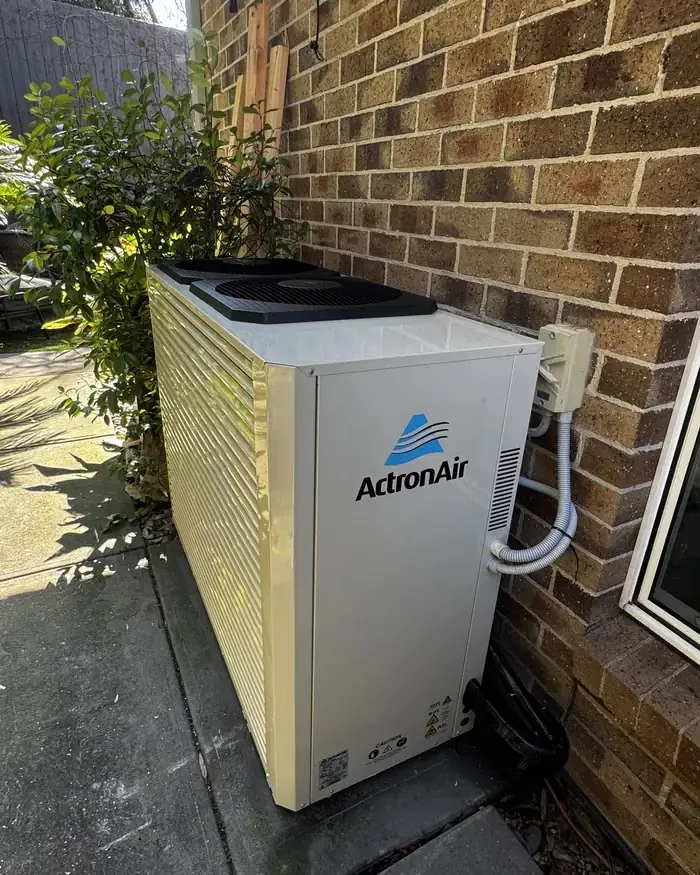 ActronAir outdoor unit installed against a brick wall
