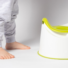 child standing beside potty