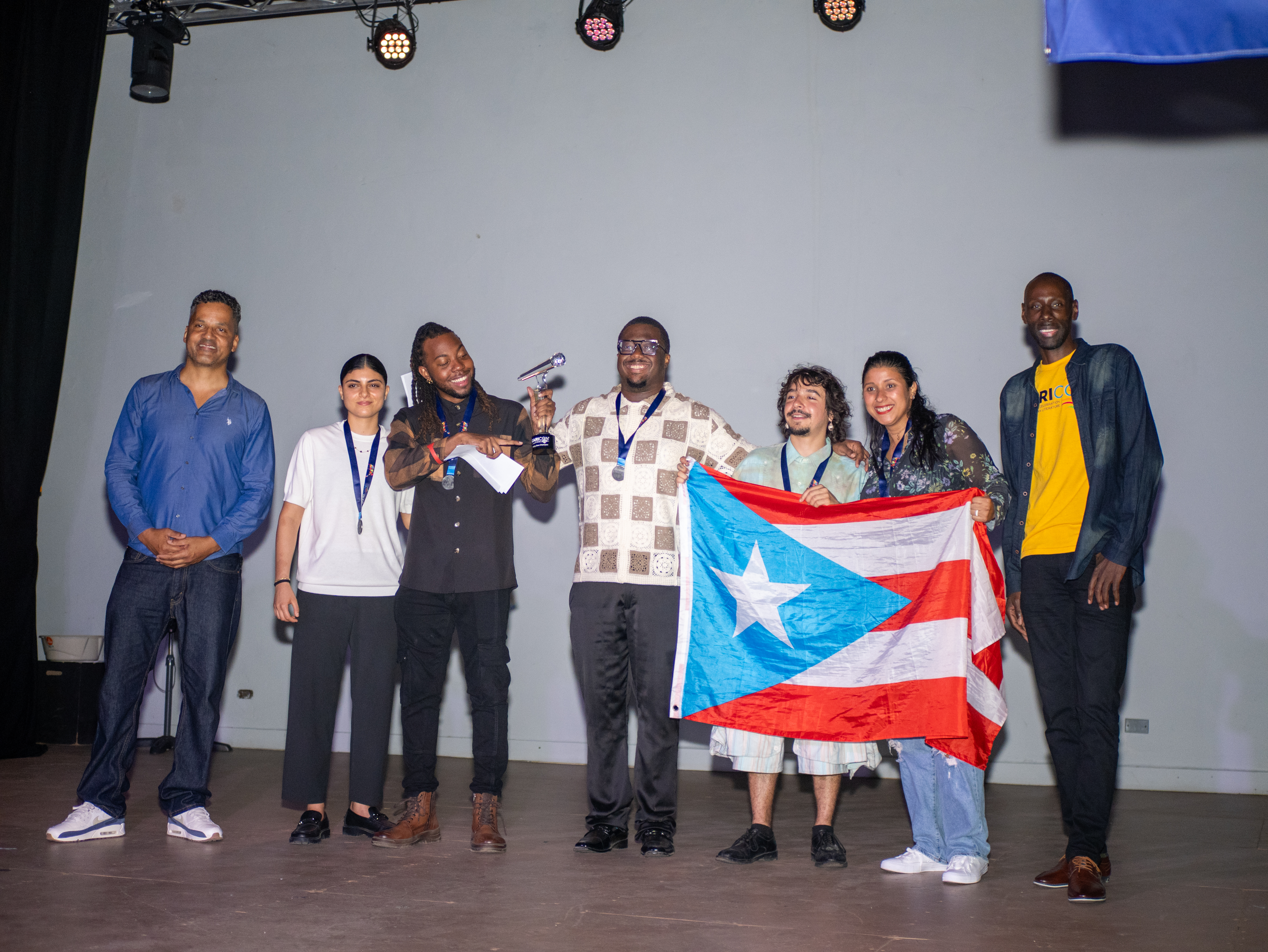Akeem Chandler-Prescod raises the CARICON Poetry Slam trophy in Willemstad