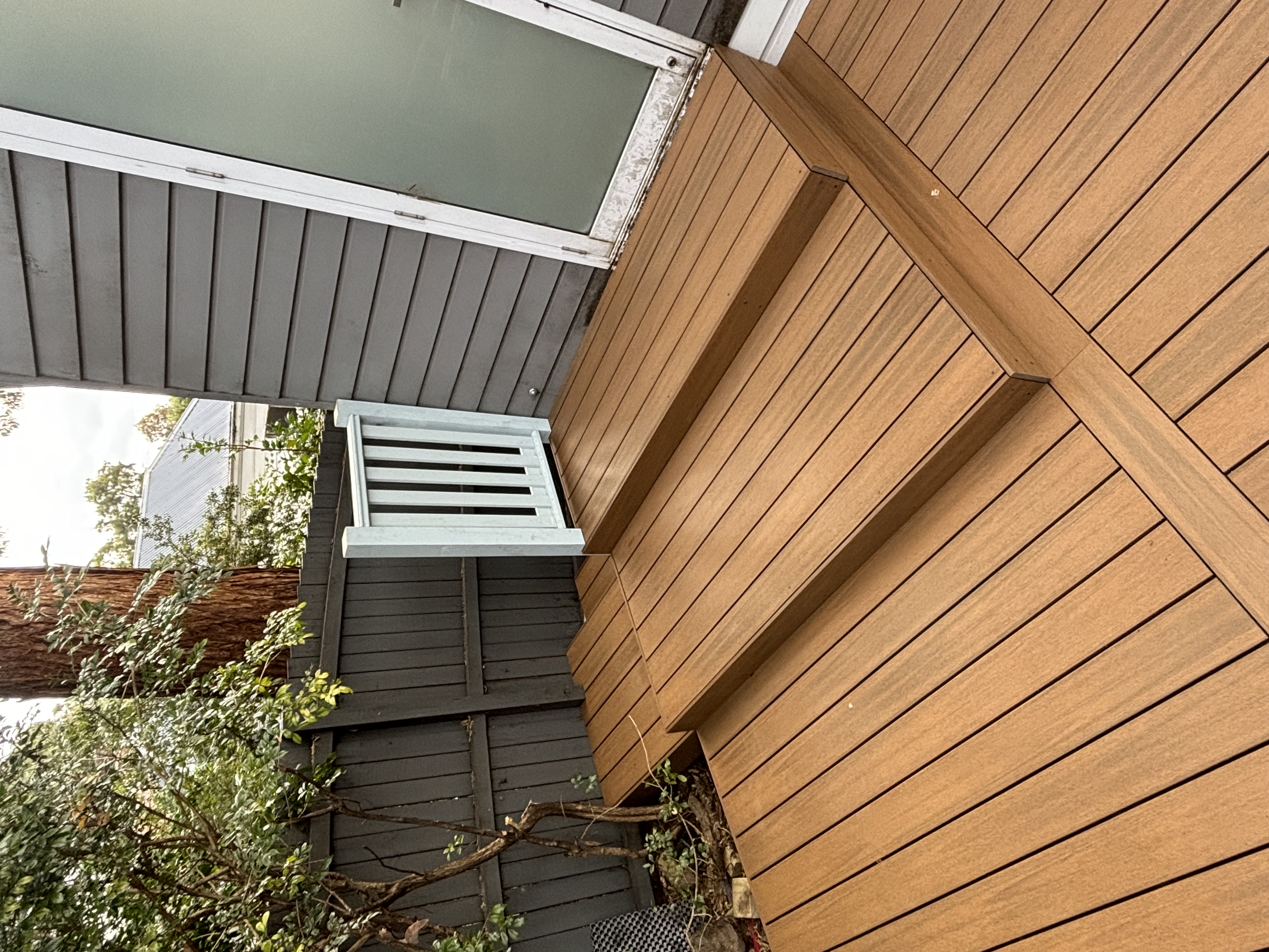 Composite deck with built-in step leading to a side door