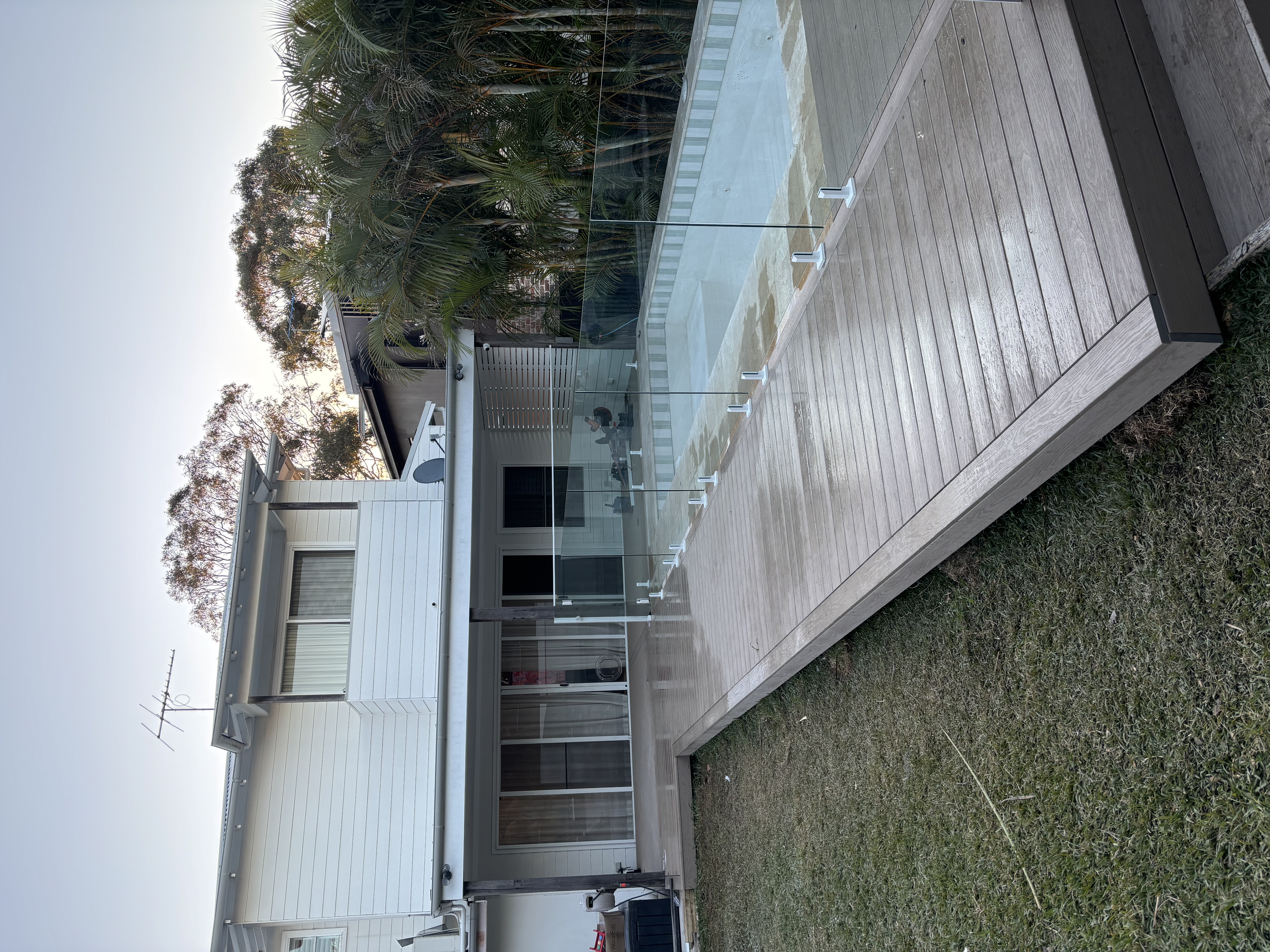 Grey composite pool deck along the back of a two-storey home