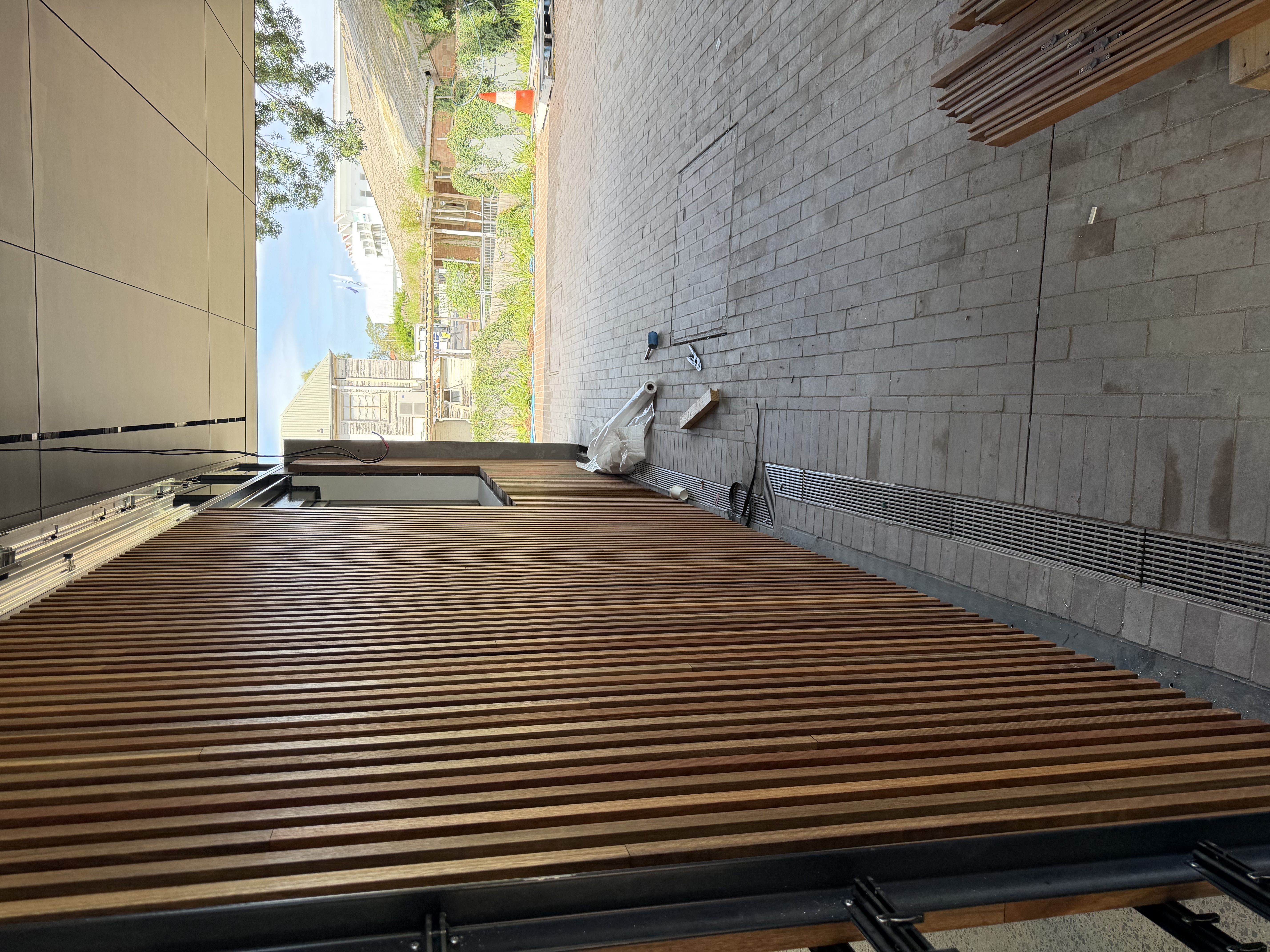 Floor-to-ceiling hardwood batten wall under a covered carport