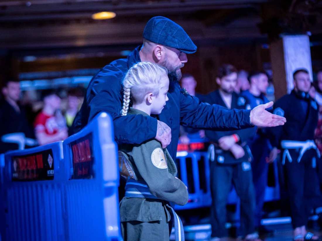 Coach Seb walking a young SPG competitor to the mat