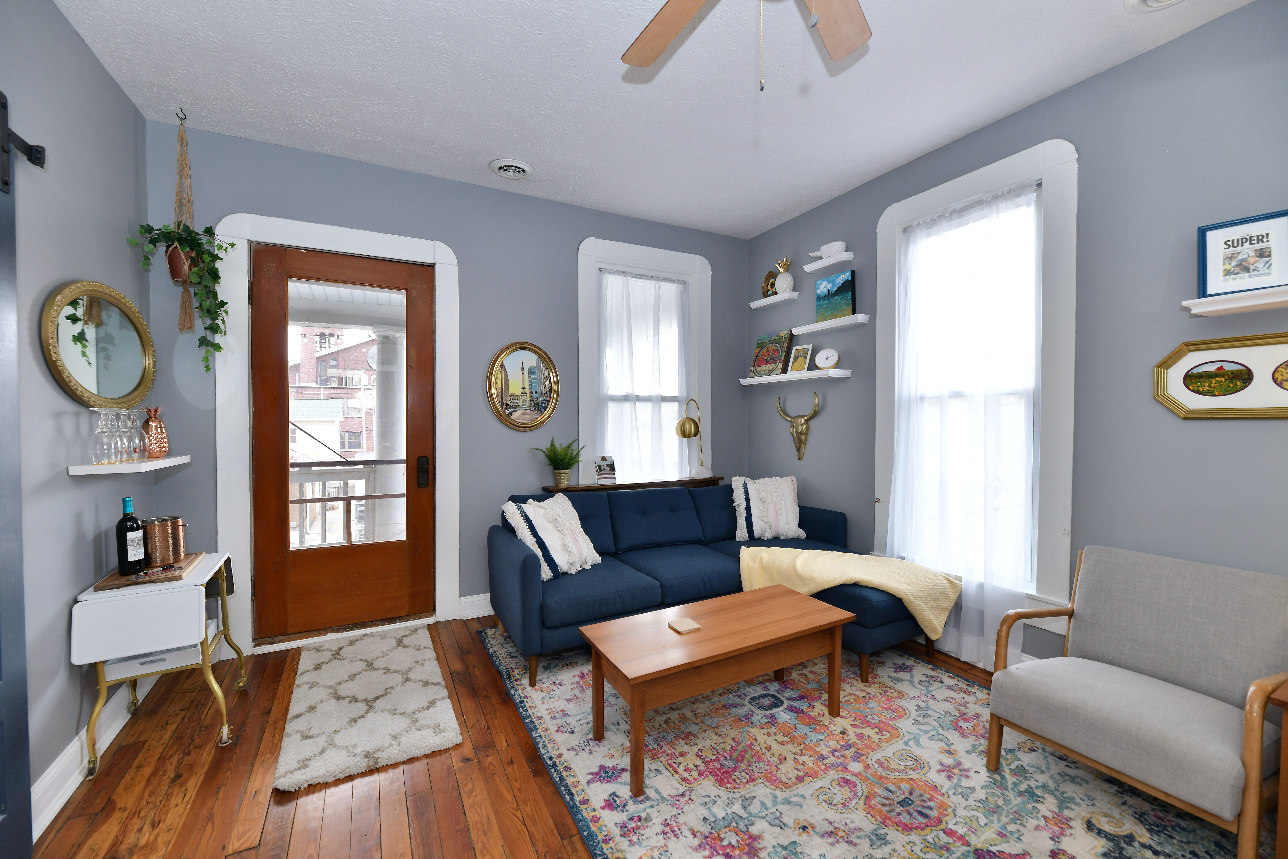 Bright and inviting living room inside KKT Vacay Properties' furnished mid-term rental in Fletcher Place, Indianapolis, featuring comfortable seating, hardwood floors, natural light, and a welcoming space for extended stays.