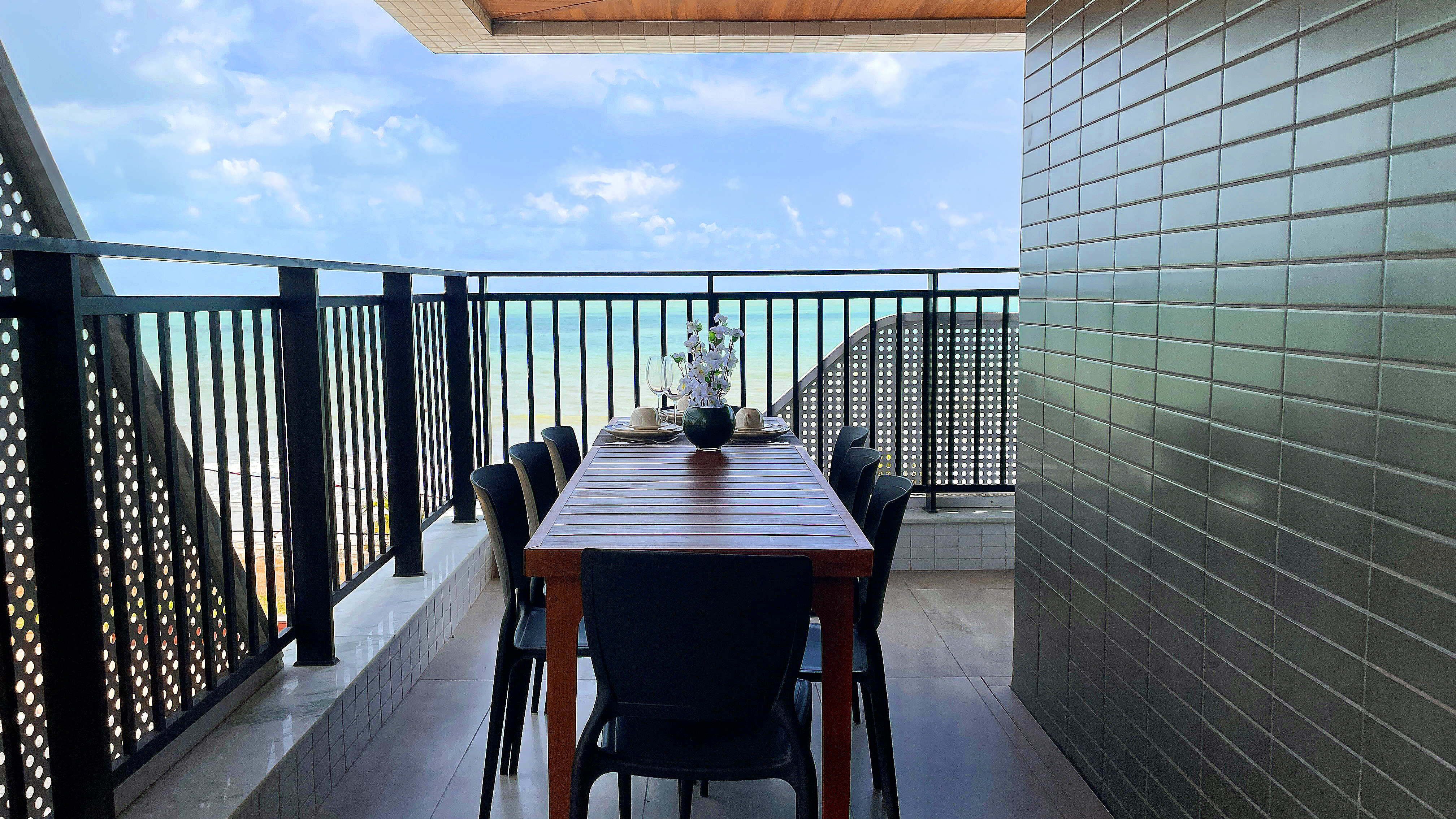 Varanda com mesa de jantar e vista mar do Bessa