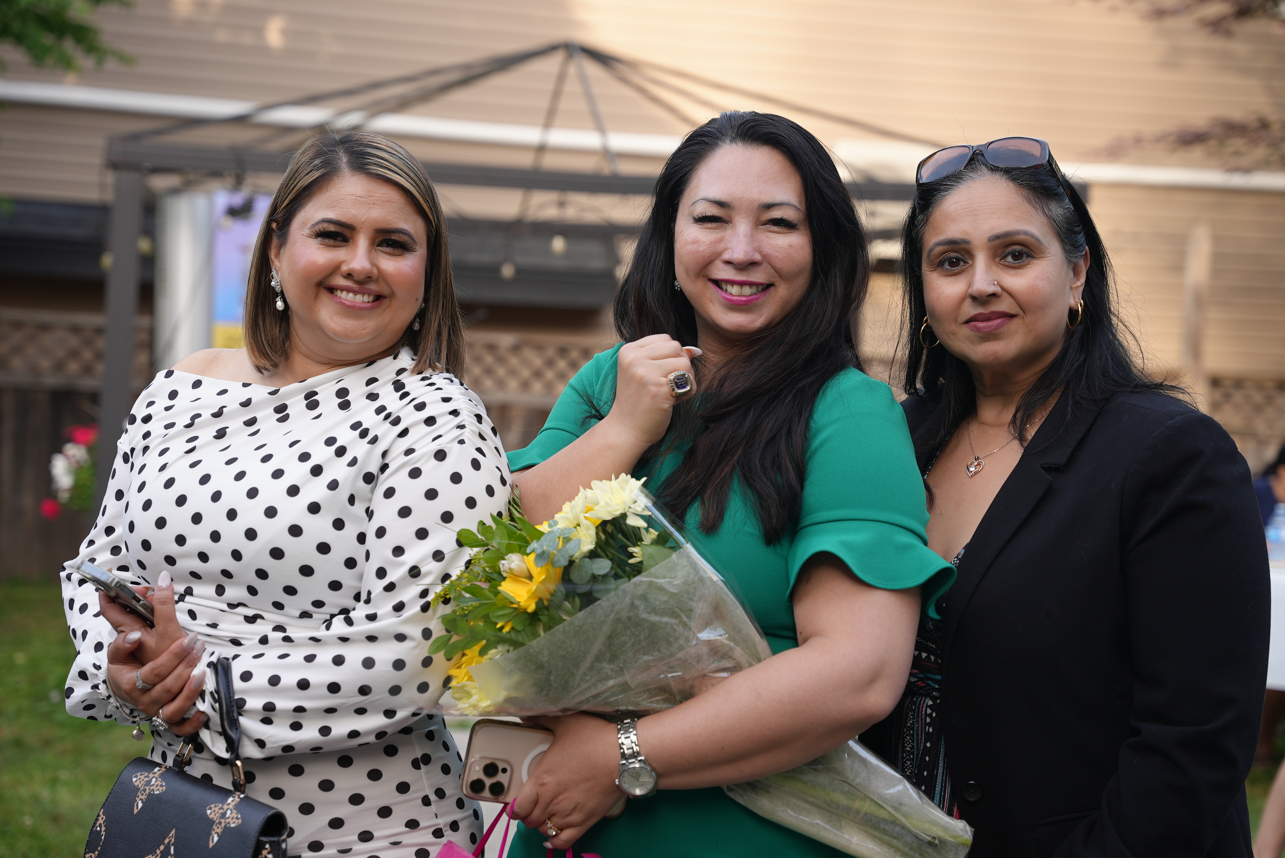 Naomi with flowers celebrating with happy clients