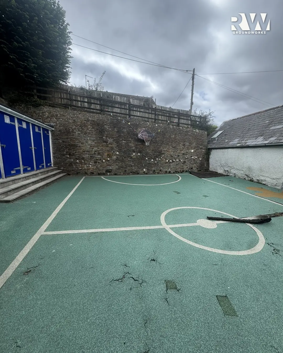 Flushing School playground before: cracked, worn green surface with faded court markings