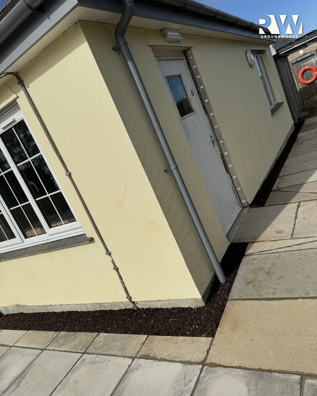 New paving to the fire door with a bark border at Gwinear Community Primary School