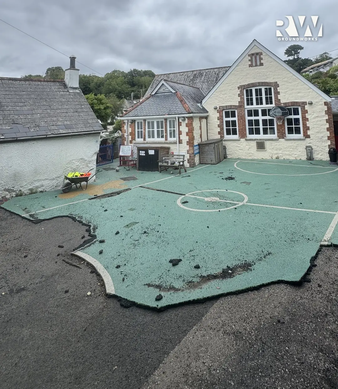 Flushing school playground before: the old green surface lifted in front of the school building