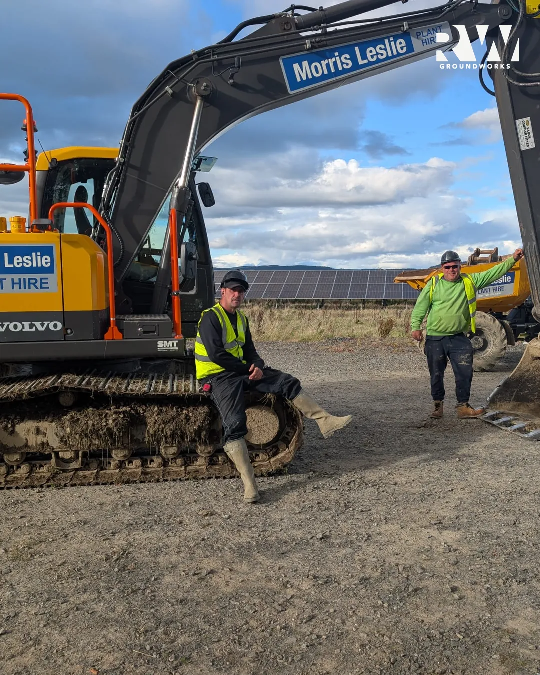 Two operatives standing by the excavator on the solar farm