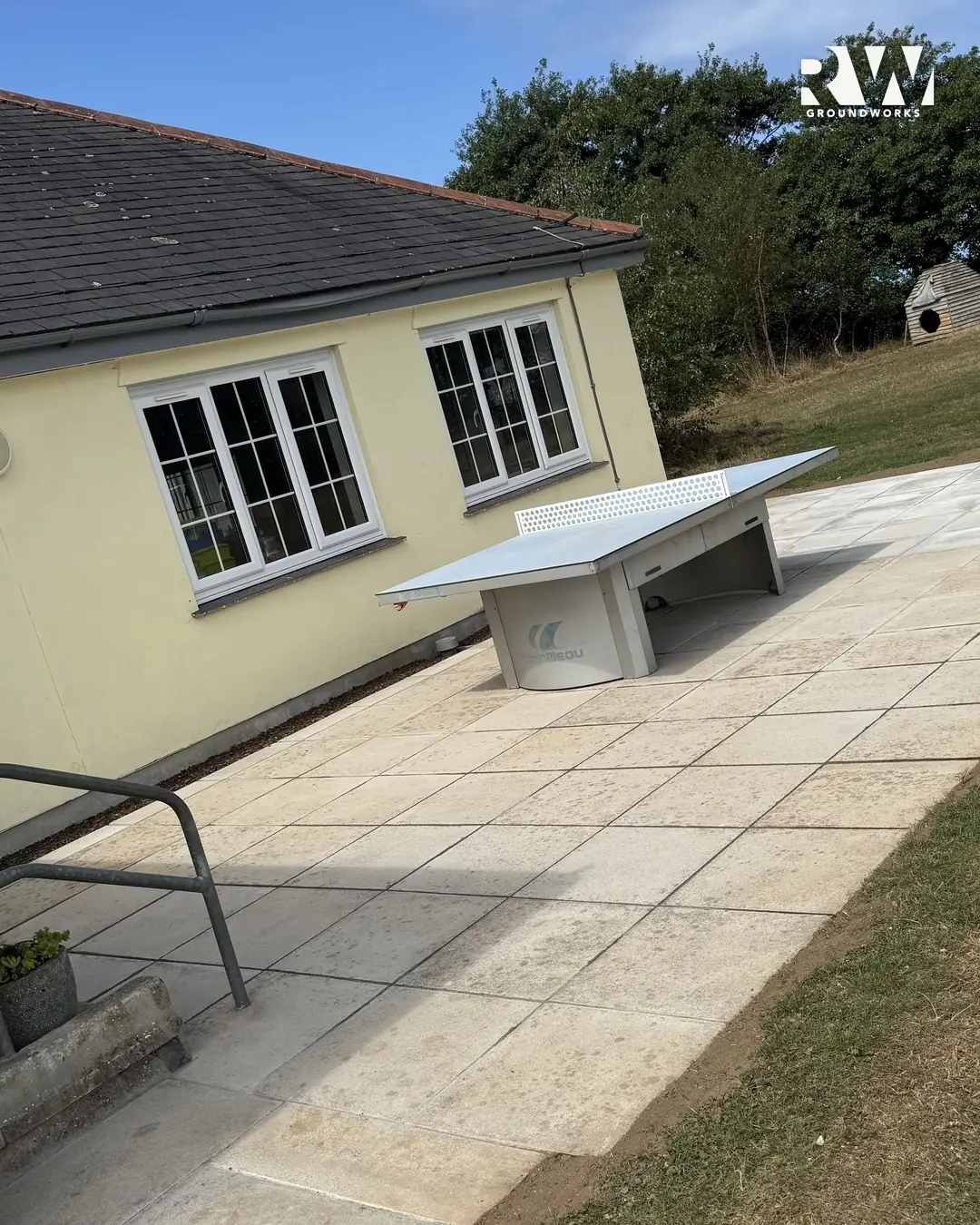 Paved terrace with handrail and steps down to the playing field at Gwinear Community Primary School