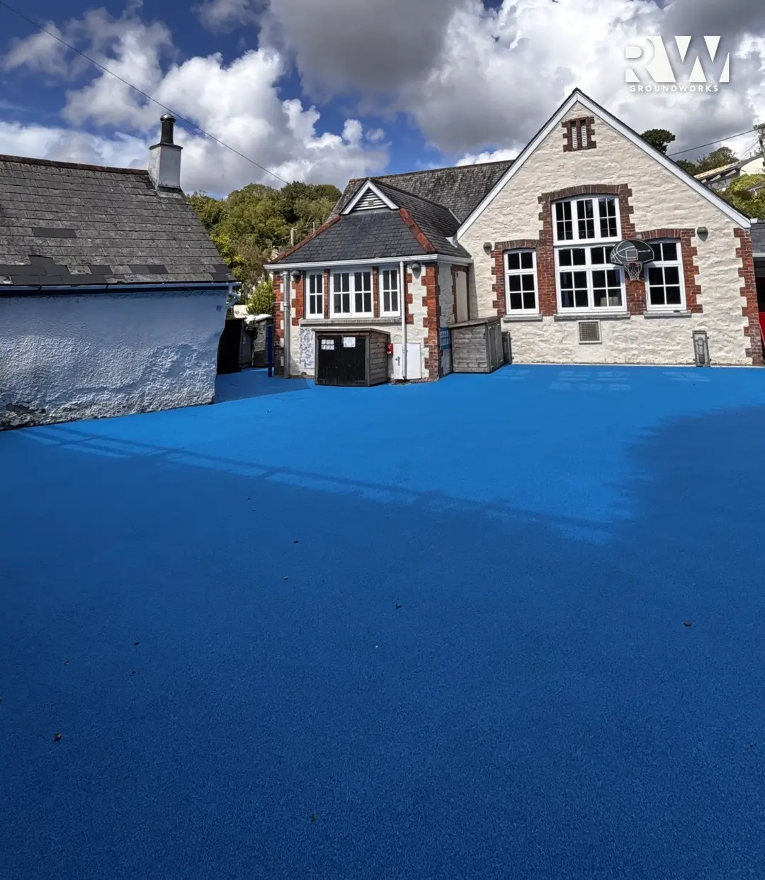 Flushing school playground after: new blue wet-pour safety surface laid by RW Groundworks in front of the school