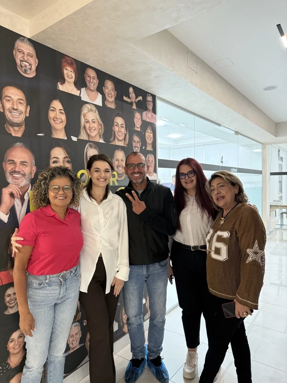 Pazienti dall'Italia con Inga, davanti al muro dei sorrisi