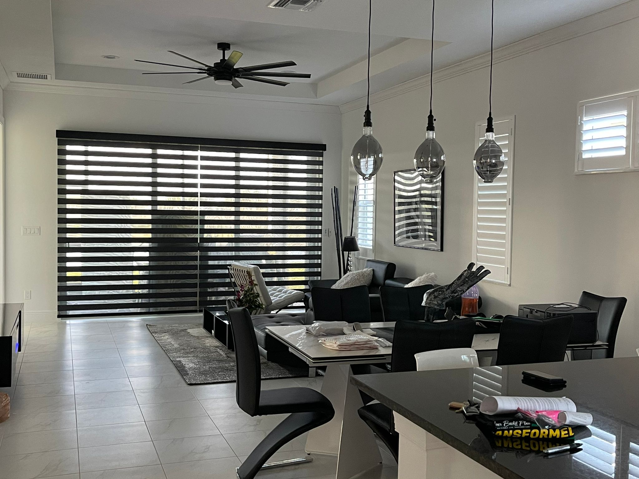 Dark zebra shade over a sliding door in an open kitchen and living area