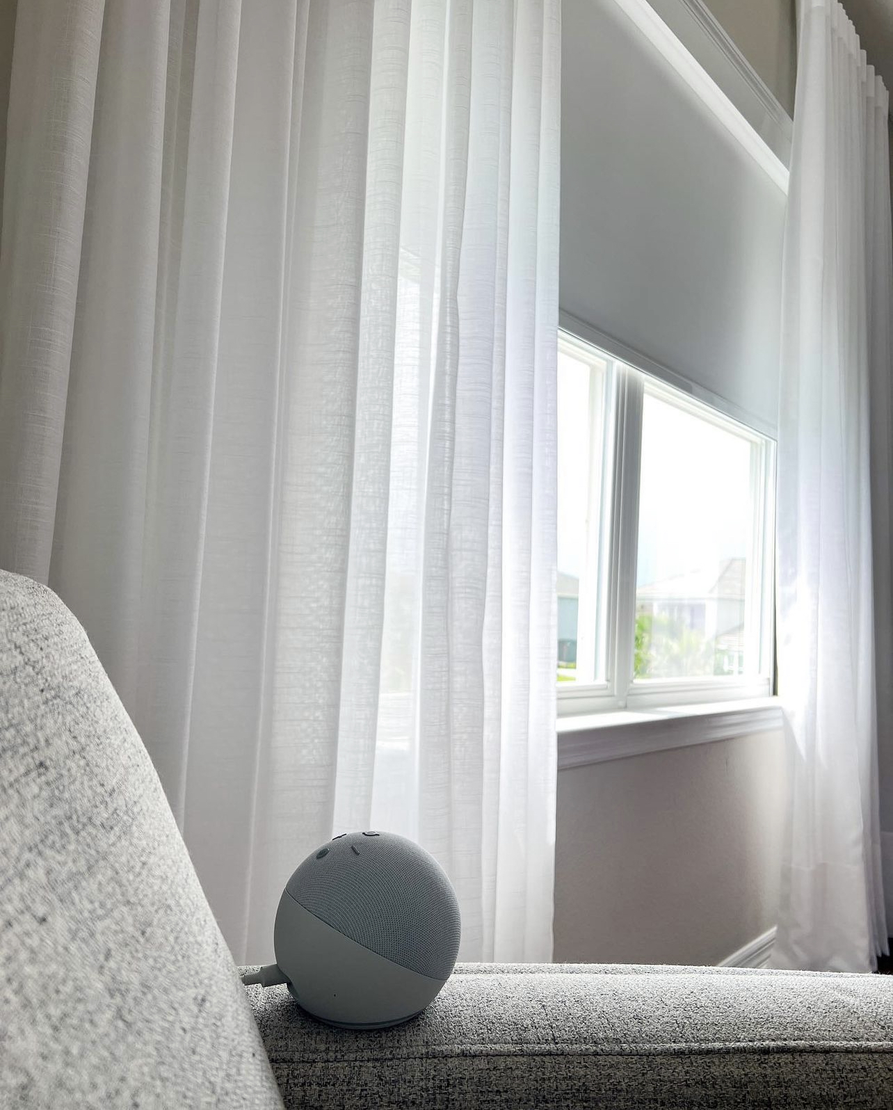 Sheer drapery layered over a roller shade, close-up