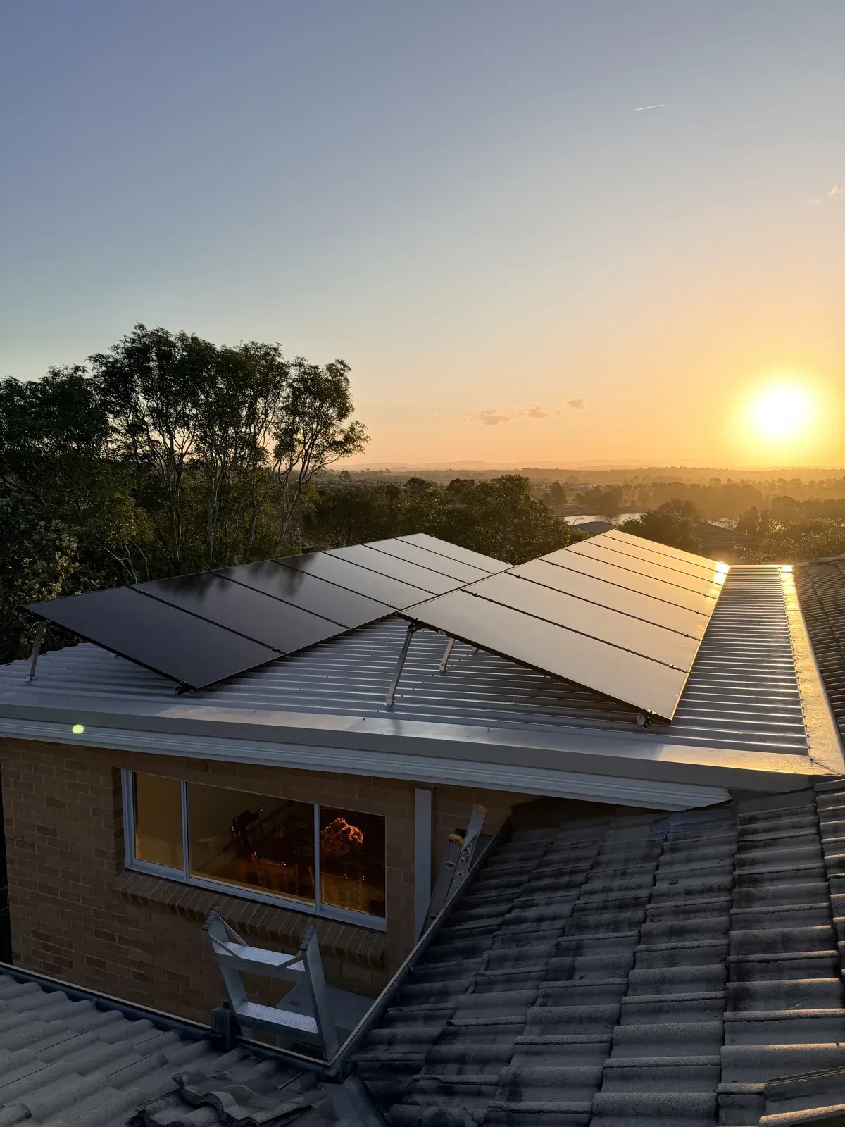 Solar panels on a home's roof at sunset, installed by Dunamis Power