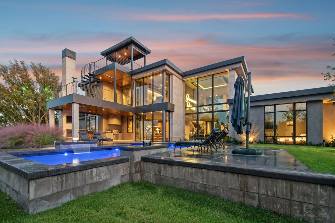 Single-story modern home with a stone path at dusk