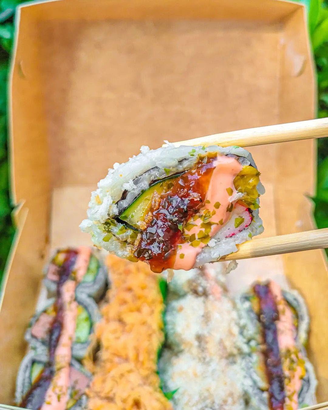 Cali Maki roll, cross-section, held with chopsticks
