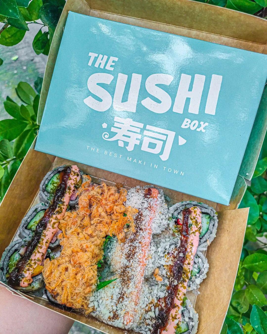 The Sushi Box open, showing the branded lid and assorted maki rolls inside