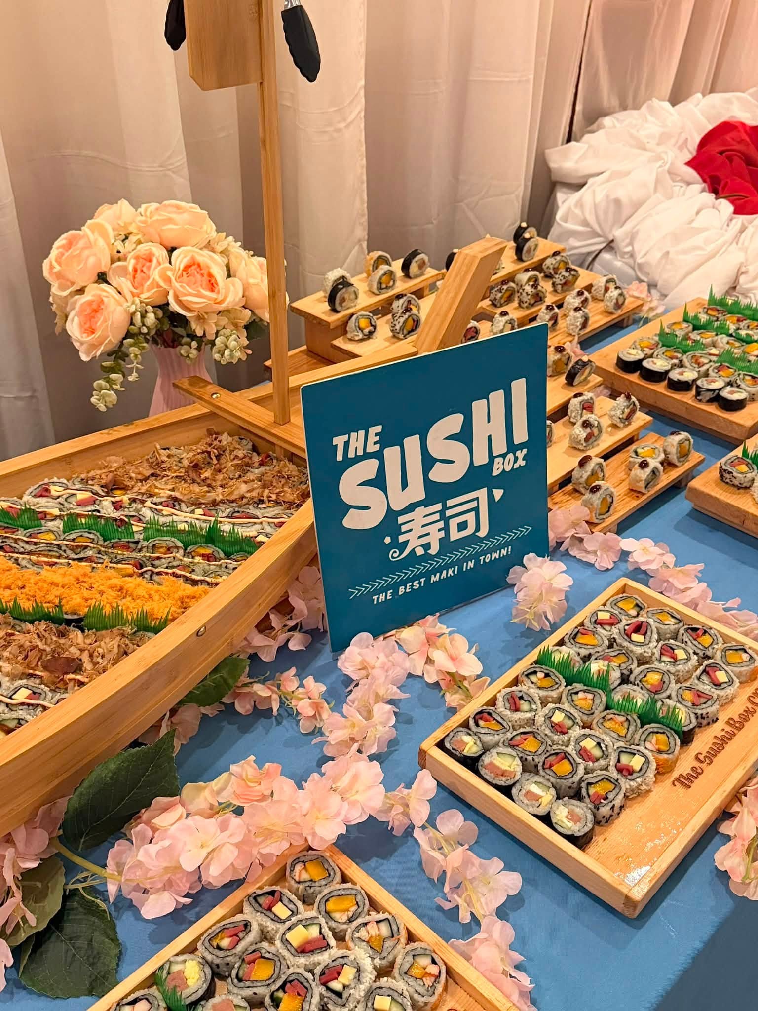 Wooden sushi boat centerpiece with The Sushi Box signage