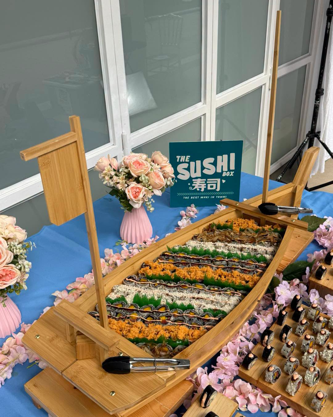 Close-up of the sushi boat with wooden serving boats stacked alongside