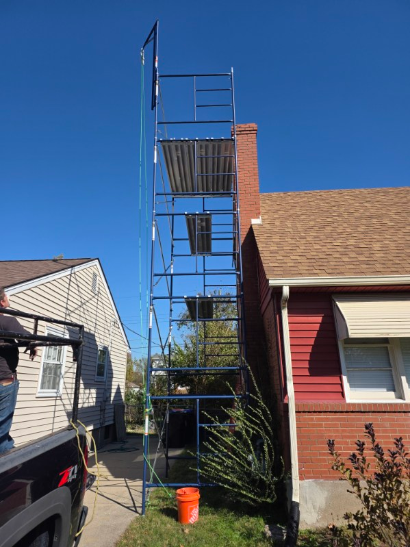 Technician working with a chimney cap and venting system