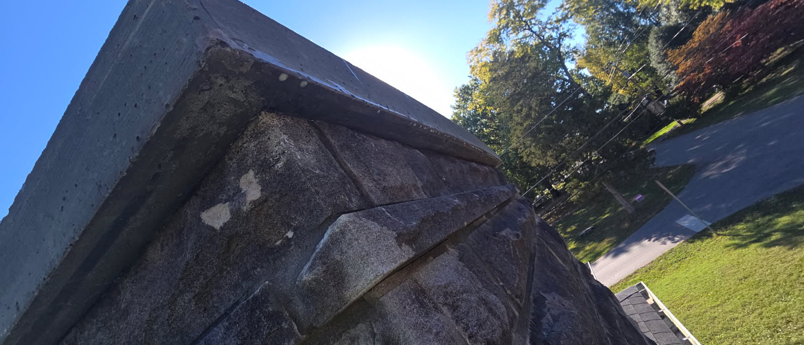 Technician inspecting a masonry chimney from the roof