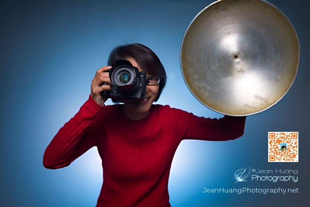 Portrait photographer Jean Huang holding a professional camera and lighting reflector during a celebrity style portrait session in Los Angeles.