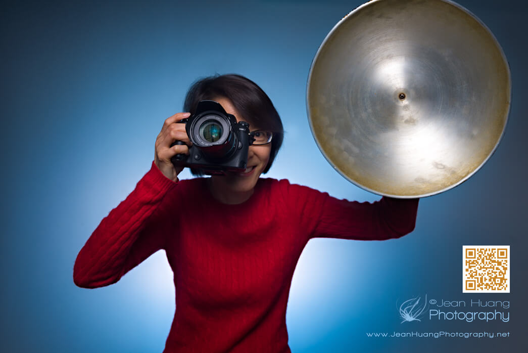 Portrait photographer Jean Huang holding a professional camera and lighting reflector during a celebrity style portrait session in Los Angeles.