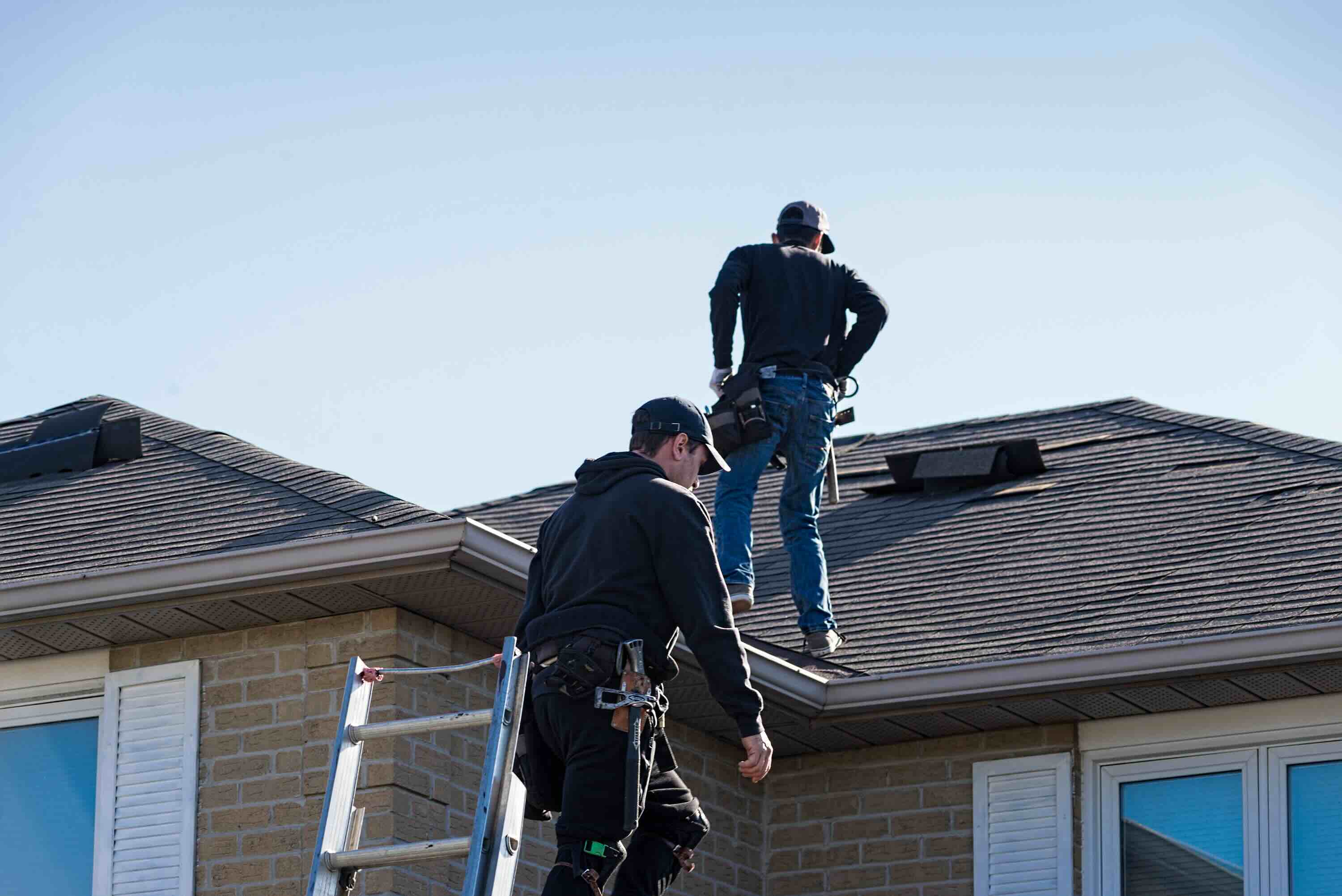 Roofers inspecting a residential roof