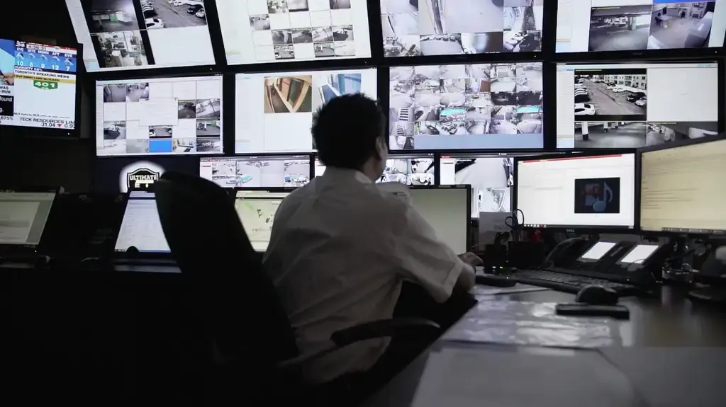 Operator watching a wall of live camera feeds in the operations centre