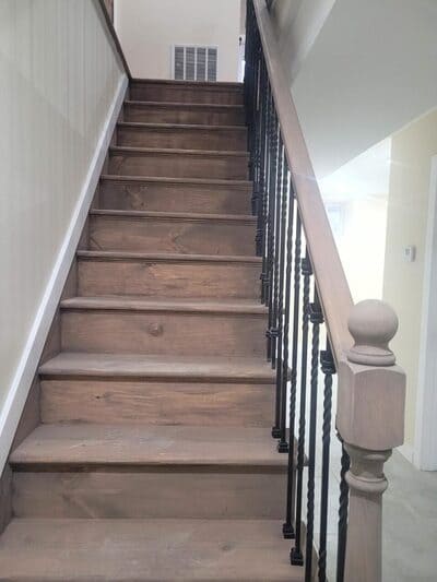 Rustic wooden staircase with black railings