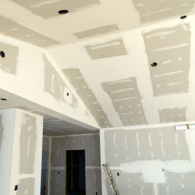 New drywall installation in progress on walls and ceiling.