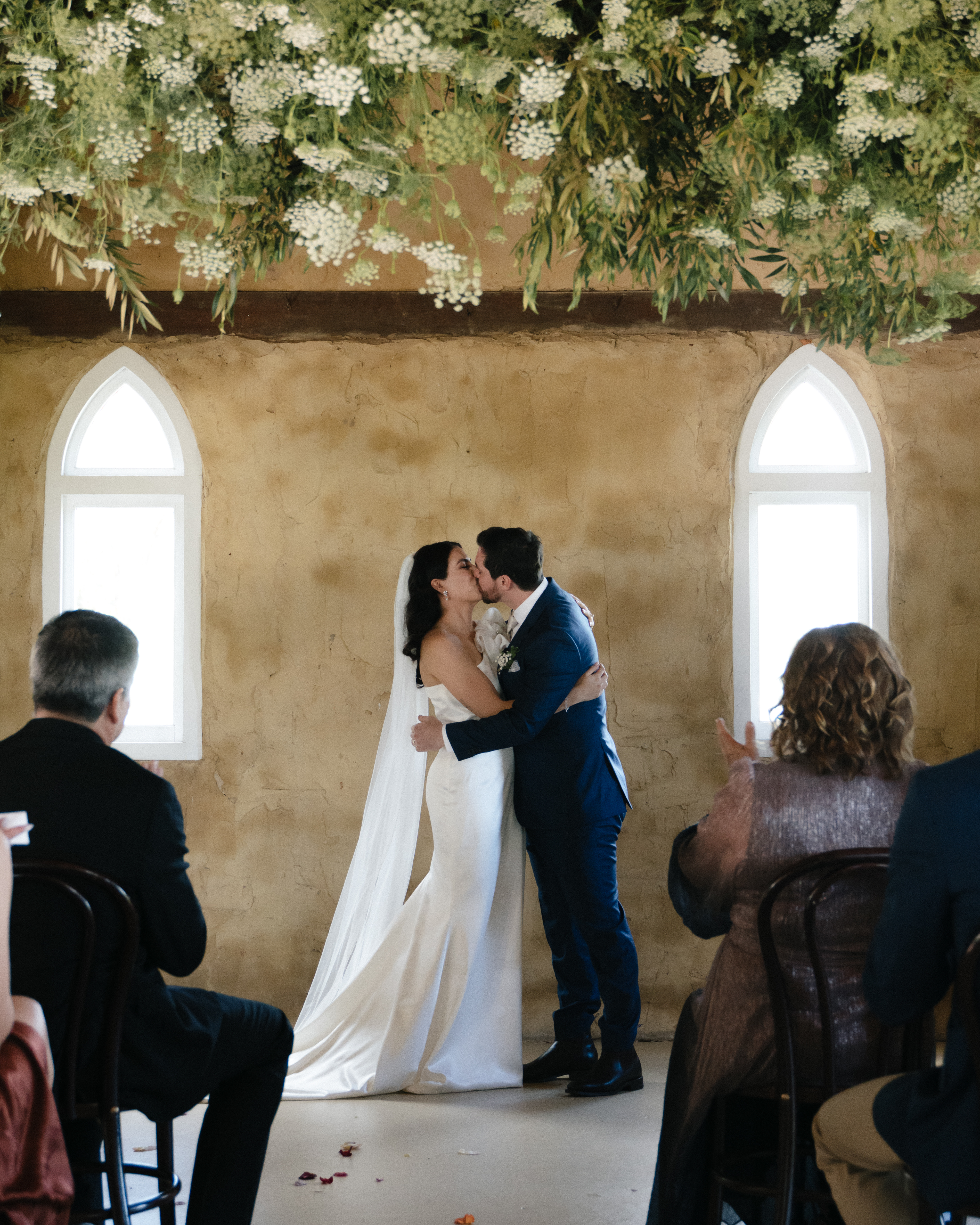 A couple's first kiss during their chapel wedding ceremony, captured by Alegre Weddings