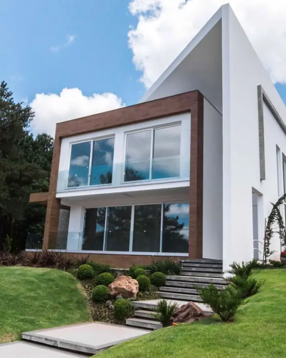 Casa con ventanas de PVC blanco y barandal de cristal