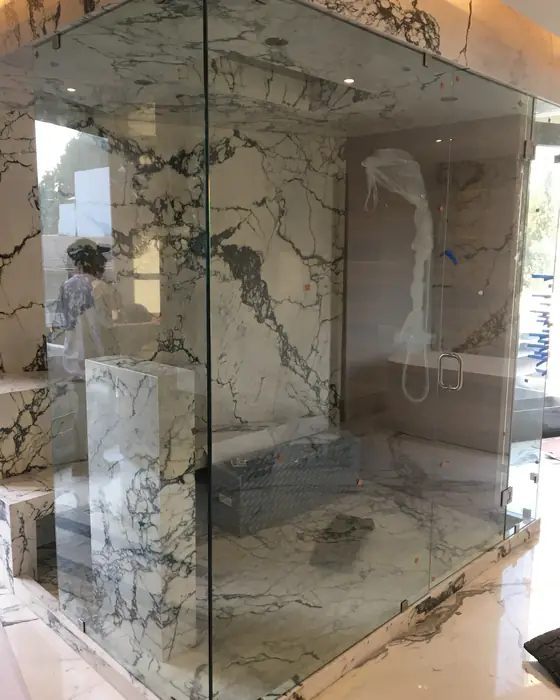 Cancel de baño de cristal templado piso a techo en regadera de mármol