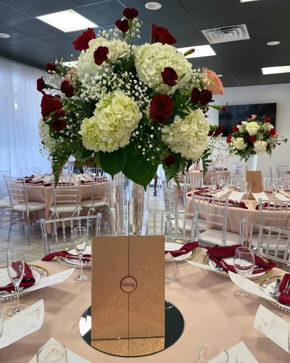 A close view of a table centerpiece with deep red and white roses