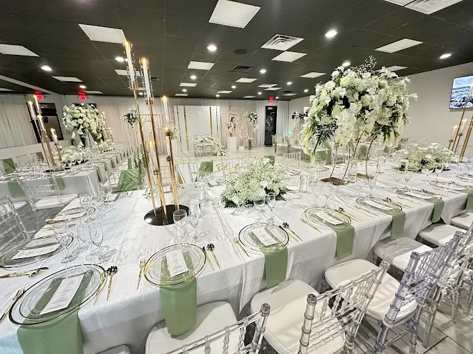 Tall white floral centerpieces and draping arranged for a wedding reception